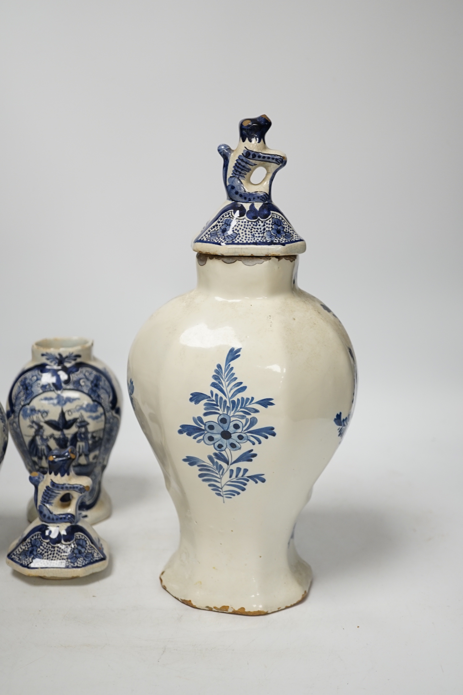 An 18th century Delft blue and white vase and a pair of later Delft vases and covers, tallest 23.5cm